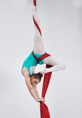 Gymnastics, aerial acrobat and silk with a woman in air for performance, sports and balance. Young...
