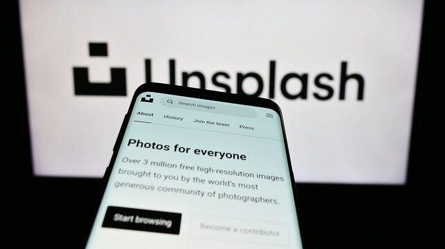 Stuttgart, Germany - 08-18-2023: Mobile phone with website of stock photography company Unsplash Inc. on screen in front of business logo. Focus on top-left of phone display.