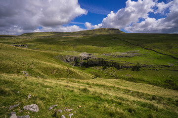 Fototapeta na wymiar View of one of the three Yorkshire Peaks - Penyghent (Pen-y-ghent) in the Yorkshire Dales National Park. In the foreground is Horton Scar.