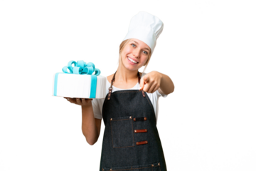 Young pastry blonde woman with a big cake over isolated chroma key background pointing front with happy expression