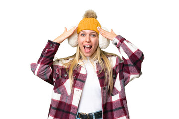 Young pretty blonde woman wearing winter muffs over isolated chroma key background with surprise...