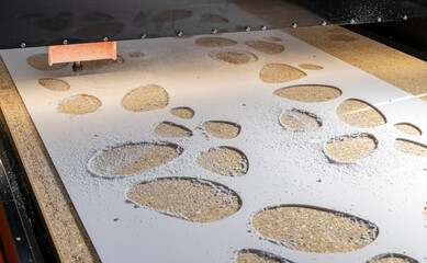 orange cnc machine in work cuts white plastic with a small cutter