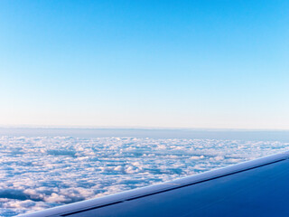 Fototapeta na wymiar View to sky and clouds on sunrise from airplane