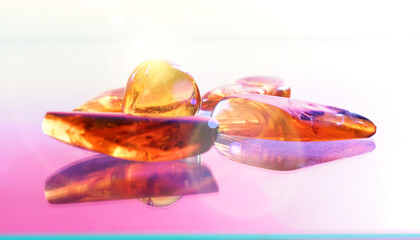 Amber gemstone on pink and blue background. Shallow depth a field