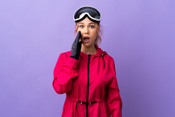 Skier teenager girl with snowboarding glasses over isolated purple background with surprise and shocked facial expression