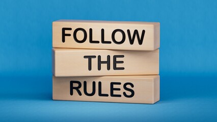 Follow the rules symbol. Concept words Follow the rules on wooden blocks. Business and follow the rules concept. Copy space.3D rendering on blue background.
 - obrazy, fototapety, plakaty