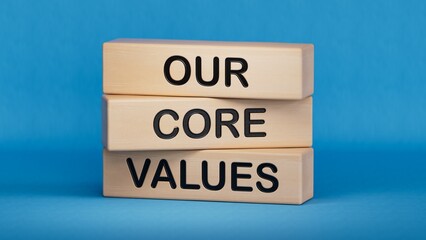 Our core values symbol. Concept words 'Our core values' on wooden blocks, businessman hand. Business and our core values concept. Copy space.3D rendering on blue background.
 - obrazy, fototapety, plakaty