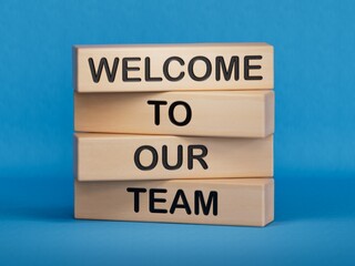 Welcome to our team symbol. Concept words Welcome to our team on wooden blocks. Businessman hand. Business, motivational and welcome to our team concept.3D rendering on blue background.  © feng