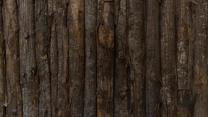 wooden poles that create the wall of a house in the mountains.