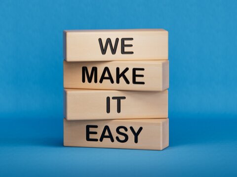 We make it easy symbol. Concept words We make it easy on wooden cubes.Businessman hand. Business motivational we make it easy concept. Copy space.3D rendering on blue background.
