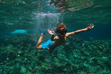 Fototapeta na wymiar Boy in goggles swimming in ocean