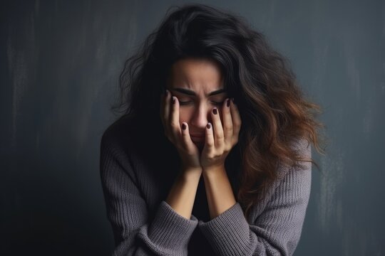 Sad depressed desperate grieving crying woman with hands covering her face and tears eyes during trouble, life difficulties, depression and mental emotional problems