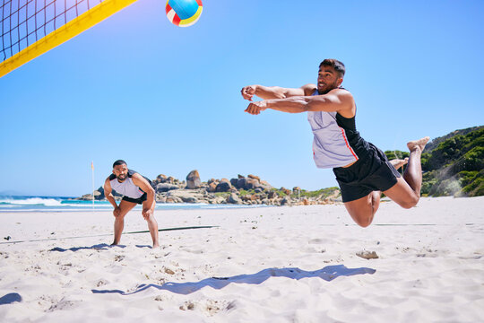 Man, game and playing volleyball on beach in sports, match or score point in outdoor fitness or exercise. Active male person in teamwork, spike or ball over net in practice or training on ocean coast