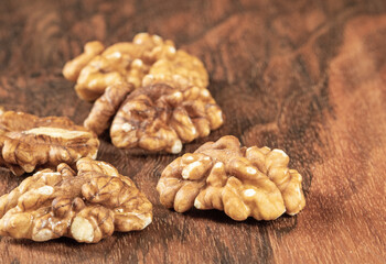 A bunch of peeled walnuts on a walnut wooden table