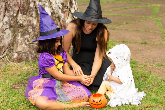 Family In Halloween Costume Celebrating And Eating Sweets