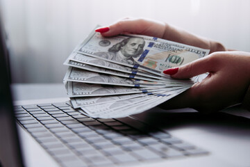 A young woman works at home on a laptop, calculating the income from the expense at the workplace in the home office. Professional freelance manager. Business people.
