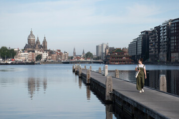 Chica caminando por el muelle en Amsterdam