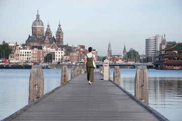 Chica caminando por el muelle en Amsterdam