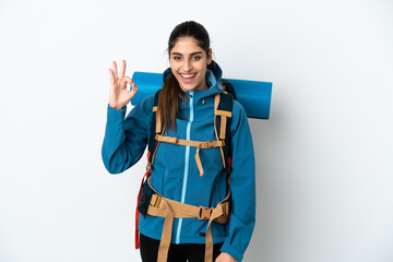 Young mountaineer man with a big backpack over isolated background showing ok sign with fingers