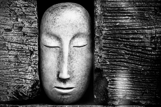 Photo artistique noir et blanc d'un visage calme et serein sculpté dans la pierre