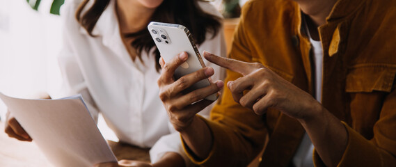 Entrepreneur Asian businessman and businesswoman discussing new business project in tablet in modern Meeting In Modern Office, Asian business casual concept.