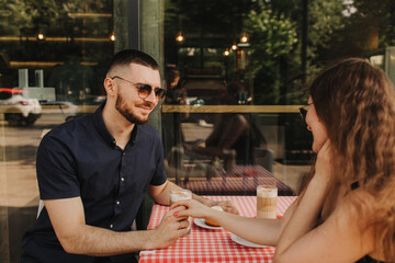 Flirting in a cafe. Beautiful loving couple sitting in a cafe enjoying in coffee and conversation. Love and romance. Blurred and noise effect. Vintage photography