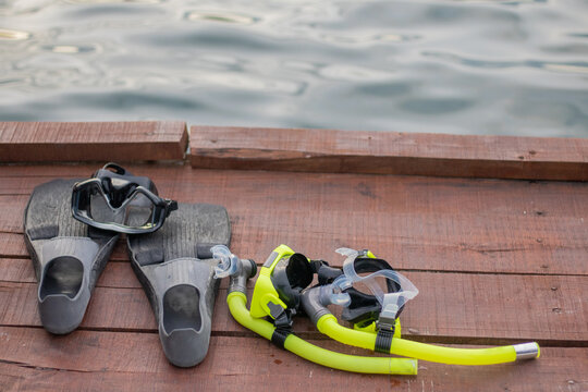 Full set of Scuba Diving equipment with selective focus on wooden pier.