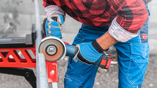 Sawing an iron pipe with an aku angle grinder.