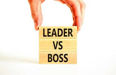 Boss vs leader symbol. Concept words Boss vs versus leader on wooden block. Beautiful white table white background. Businessman hand. Business motivational boss vs leader concept. Copy space.