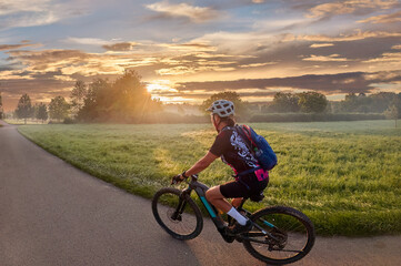 nice woman with electric mountain bike, cycling in moody morning light on the Neckar valley bicycle...