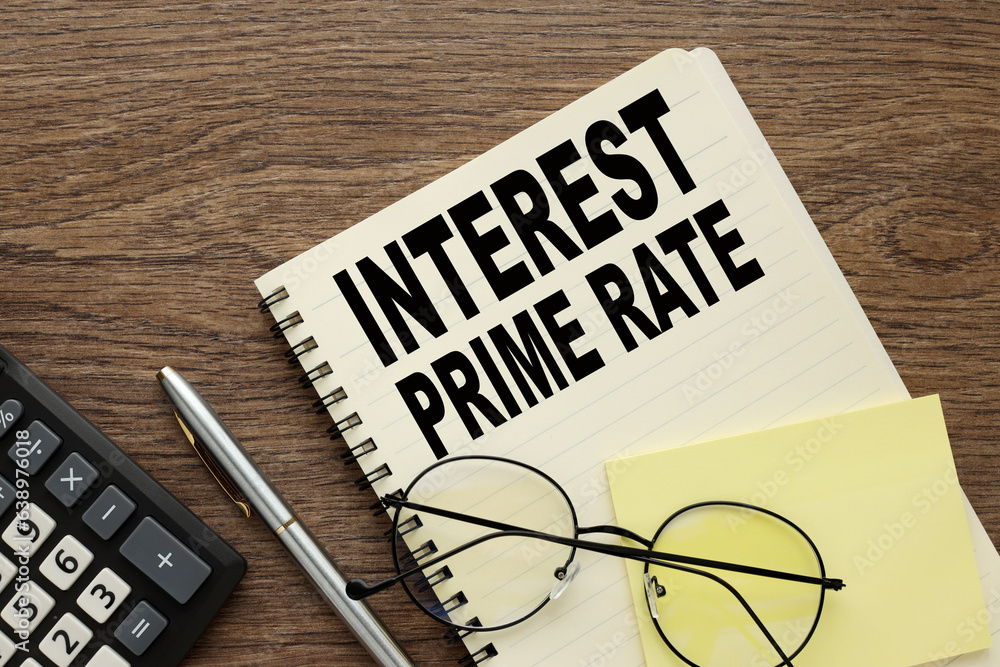 Poster glasses and a calculator lie on a notebook with words interest prime rate.