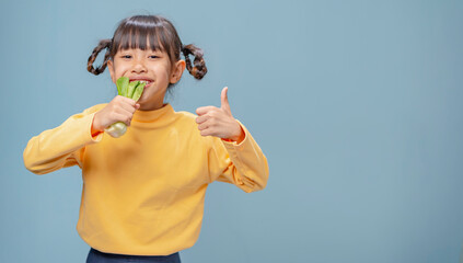 A little girl loves vegetables and is eating vegetables.