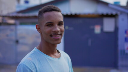 Portrait of a young black South American man smiling at camera, close-up face of a cheerful happy...
