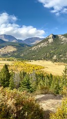 Fototapeta premium Estes Park View Estes Park transforms into a breathtaking canvas of autumnal colors during the fall season. The lush greenery of summer gives way to a rich tapestry of red, orange, and golden hues. 