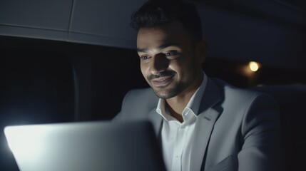 Businessman travels business class aboard a private jet. Man works on a laptop near the porthole. Business traveling concept.