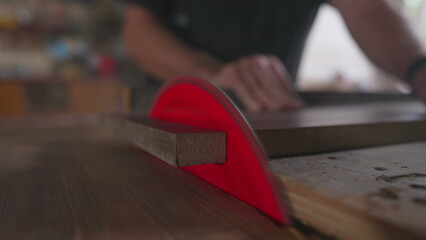 Close-Up Detail of Wood Being Sliced by Saw Machine in Workshop