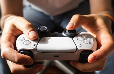 Frontal photo of White video game controller held by two man hands at noon