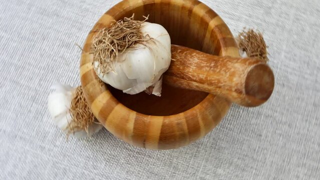 garlic and pestle rotating. Food background. 4k video capture