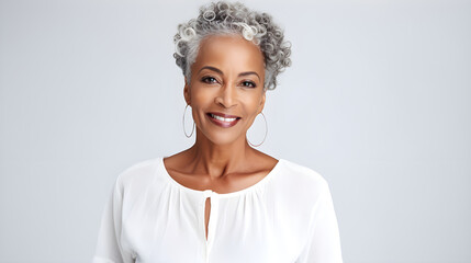 Close up portrait of a beautiful smiling black African-American woman of her 50s mid age on neutral background. Healthy face skin care beauty, skincare cosmetics, dental