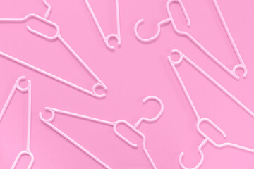 Plastic hangers on a pink background. Concept for sale, shop, second hand, online trade, brand...