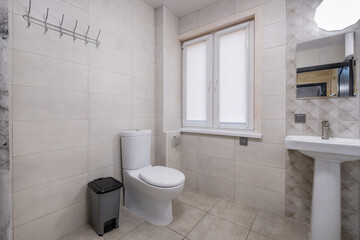 toilet and detail of a corner shower cabin with wall mount shower attachment