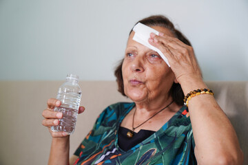 senior woman sweating suffering heat stroke at home