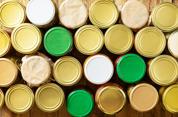 Various types of canned vegetables in glass jars on a rustic table. Healthy homemade fermented food. Home economics, autumn harvest preservation. View from above.