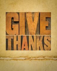 Give thanks word abstract in letterpress wood type on art paper, Thanksgiving and fall holidays theme.