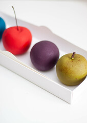Modern realistic fruit pastries made of chocolate and mousse. Red apple, green apple, blueberry and passion fruit for cafe or restaurant