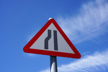 road narrowing ahead on the left warning sign for motorists. Left lane narrows triangular warning sign