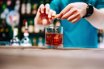 man bartender hand making negroni cocktail in bar