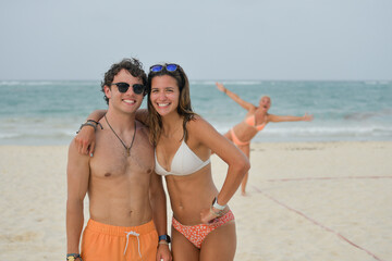 Young couple on the beach with background photobomb