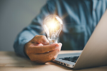Creative businessman holds a light bulb, representing a bright idea. Showcases the concept of...
