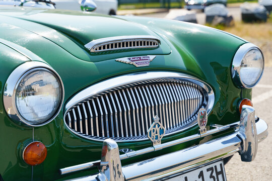 Vintage Austin Healey 3000. Front view of the hood, grille, chrome bumper and headlights.